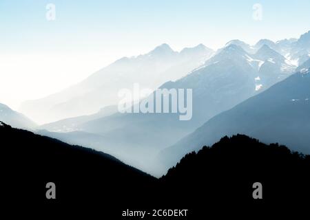 Vue spectaculaire sur les silhouettes des chaînes de montagnes et le brouillard dans les vallées. Vue depuis le sommet du mont Corno di Tres, Tresner Horn. Trentin, Tyrol du Sud, Alpes Banque D'Images