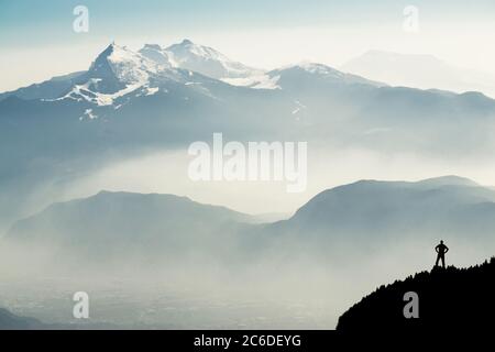 Des silhouettes spectaculaires dans les chaînes de montagnes. Homme atteignant le sommet en profitant de la liberté. Vue depuis le sommet du mont Corno di Tres, la corne de Tresner jusqu'à Cima Paganella Banque D'Images