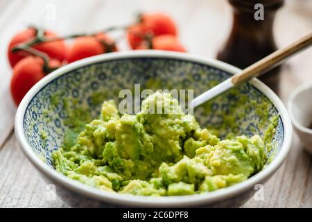 Écrasée avocat dans un bol. Sauce guacamole, purée d'avocat. Gros plan, mise au point sélective Banque D'Images