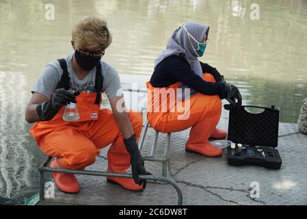 Surabaya, Indonésie. 09e juillet 2020. Un militant indonésien de l'environnement de l'Ecologie et de la conservation des zones humides (Ecotec) a vu tenir un échantillon d'eau dans les rivières Kalimas, Surabaya, Indonésie, lors de la manifestation contre l'utilisation abusive des plastiques jetables, du chlore et du microplastique, le 9 juillet 2020. (Photo de Julian Romadhon/INA photo Agency/Sipa USA) crédit: SIPA USA/Alay Live News Banque D'Images