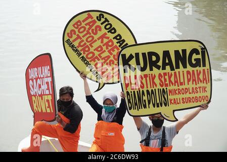 Surabaya, Indonésie. 09e juillet 2020. Les militants indonésiens de l'environnement de l'Ecologie et de la conservation des zones humides Institute (Ecotec) ont vu tenir des plaques sur un bateau dans les rivières Kalimas, Surabaya, Indonésie, lors de la manifestation contre l'utilisation abusive des plastiques jetables, du chlore et du microplastique, le 9 juillet 2020. (Photo de Julian Romadhon/INA photo Agency/Sipa USA) crédit: SIPA USA/Alay Live News Banque D'Images