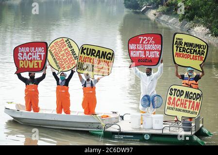 Surabaya, Indonésie. 09e juillet 2020. Les militants indonésiens de l'environnement de l'Ecologie et de la conservation des zones humides Institute (Ecotec) ont vu tenir des plaques sur un bateau dans les rivières Kalimas, Surabaya, Indonésie, lors de la manifestation contre l'utilisation abusive des plastiques jetables, du chlore et du microplastique, le 9 juillet 2020. (Photo de Julian Romadhon/INA photo Agency/Sipa USA) crédit: SIPA USA/Alay Live News Banque D'Images