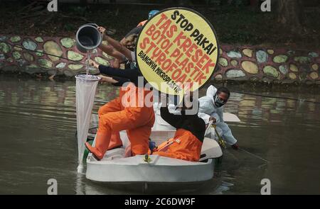 Surabaya, Indonésie. 09e juillet 2020. Les militants indonésiens de l'environnement de l'Ecologie et de la conservation des zones humides Institute (Ecotec) ont vu tenir des plaques sur un bateau dans les rivières Kalimas, Surabaya, Indonésie, lors de la manifestation contre l'utilisation abusive des plastiques jetables, du chlore et du microplastique, le 9 juillet 2020. (Photo de Julian Romadhon/INA photo Agency/Sipa USA) crédit: SIPA USA/Alay Live News Banque D'Images