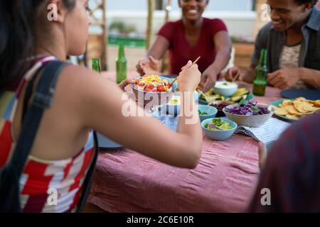 Jeunes amis qui mangent des tacos à la table du patio Banque D'Images