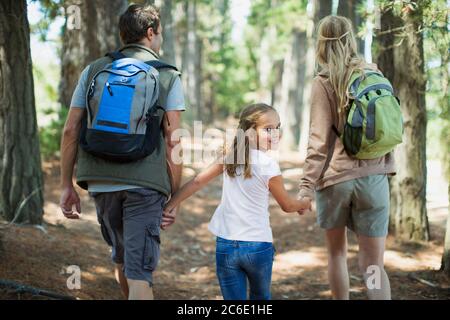 Fille souriante randonnée avec parents dans les bois Banque D'Images