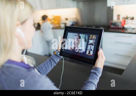 Femme discutant vidéo avec ses amis sur une tablette numérique Banque D'Images