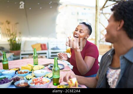 Jeune femme prenant un déjeuner à tacos à table de patio Banque D'Images