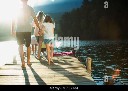 Famille marchant sur le quai au-dessus du lac Banque D'Images