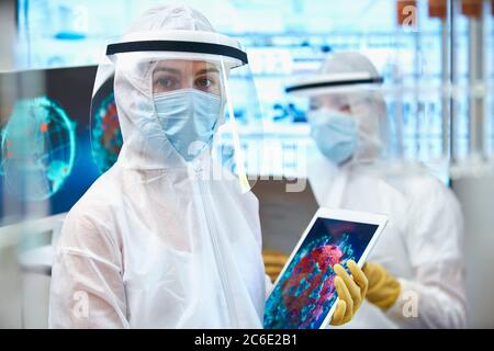 Portrait de la scientifique féminine en costume propre à la recherche du coronavirus Banque D'Images