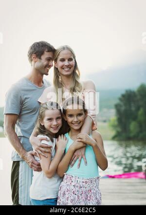 Famille souriante sur le quai au-dessus du lac Banque D'Images