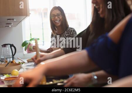 Les femmes indiennes joyeuses cuisent de la nourriture dans la cuisine Banque D'Images