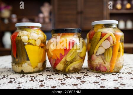 Mise en conserve à domicile de légumes d'été stockés sur la table. Les rois de la maison de grand-mère - variété de légumes en conserve alignés dans une rangée de pots en verre. Banque D'Images