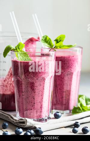 Deux verres de smoothie aux myrtilles avec garniture à la menthe sur la table. Banque D'Images