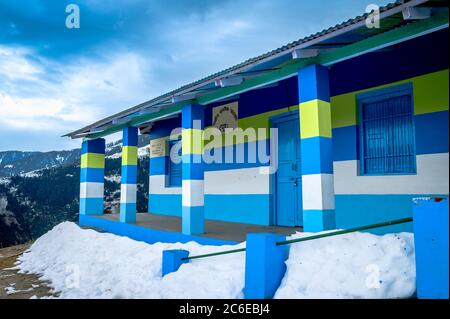 Une école de village colorée et dynamique en hiver sur les montagnes de l'Himalaya en route pour le trek de Khajjiar, Himachal Pradesh, Inde. Banque D'Images