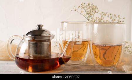 Thé matinal dans des tasses en verre isolées à double paroi et théière en verre. Tasses à thé en verre thermique. Thé du matin Banque D'Images
