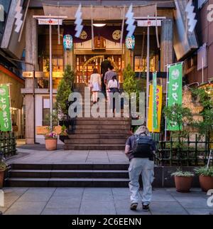 Adorateur au sanctuaire Karasumori, Shimbashi, Tokyo, Japon la nuit. Banque D'Images