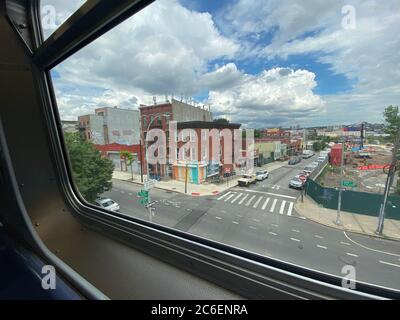 Vue par la fenêtre d'un train F surélevé dans un ciel spectaculaire au-dessus des quartiers de Gowanus/Carol Gardens à Brooklyn, New York. Banque D'Images