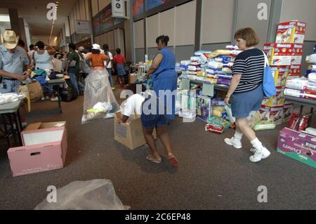 Austin, Texas le 4 septembre 2005 : les réfugiés de l'ouragan Katrina ramassent des vêtements donnés sur le site du Austin Convention Center qui abrite 4 000 personnes déplacées, principalement de la région de la Nouvelle-Orléans. De nombreux évacués ont fui leurs maisons avec peu de biens. ©Bob Daemmrich Banque D'Images
