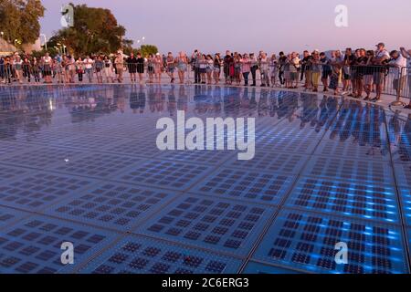 Foules au soleil Salutation au port de Zadar par l'architecte Nikola Basic qui recueille le soleil pour allumer la lumière et allumer d'autres lumières en face du port, Zadar, Croatie Banque D'Images