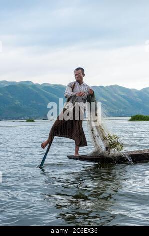 Nyaungshwe, Myanmar - 9 juin 2014 : la pagayage des pattes pendant la pêche est une compétence traditionnelle des pêcheurs du lac Inle, au Myanmar Banque D'Images