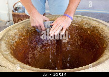 Faire un jet d'eau minérale avec ses mains dans une bouteille dans un spa Banque D'Images