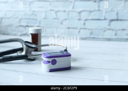 Oxymètre de pouls et stéthoscope sur table en bois. Banque D'Images