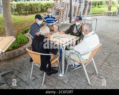Las Palmas, Grande Canarie, Îles Canaries, Espagne. 9 juillet 2020. Les hommes espagnols jouent des dominos dans le Parque Santa Catalina à Las Palmas sur Gran Canaria pour la première fois depuis le verrouillage. Le parc, qui est normalement une ruche d'activité avec des joueurs de dominos et d'échecs, a été fermé depuis le début du confinement de Covid en mars. Crédit : Alan Dawson/Alay Live News Banque D'Images