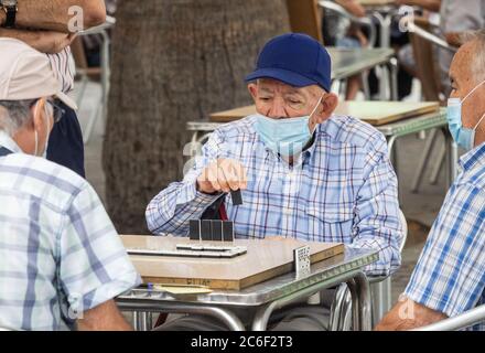 Las Palmas, Grande Canarie, Îles Canaries, Espagne. 9 juillet 2020. Les hommes espagnols jouent des dominos dans le Parque Santa Catalina à Las Palmas sur Gran Canaria pour la première fois depuis le verrouillage. Le parc, qui est normalement une ruche d'activité avec des joueurs de dominos et d'échecs, a été fermé depuis le début du confinement de Covid en mars. Crédit : Alan Dawson/Alay Live News Banque D'Images