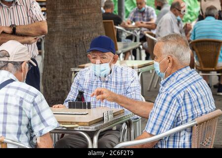 Las Palmas, Grande Canarie, Îles Canaries, Espagne. 9 juillet 2020. Les hommes espagnols jouent des dominos dans le Parque Santa Catalina à Las Palmas sur Gran Canaria pour la première fois depuis le verrouillage. Le parc, qui est normalement une ruche d'activité avec des joueurs de dominos et d'échecs, a été fermé depuis le début du confinement de Covid en mars. Crédit : Alan Dawson/Alay Live News Banque D'Images
