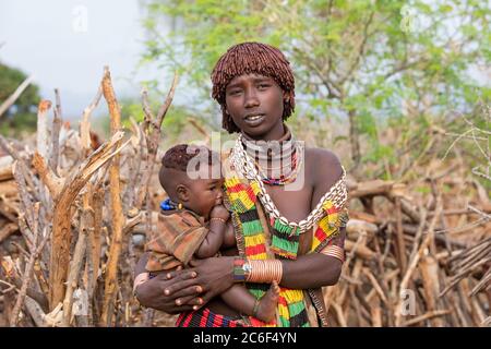 Femme noire avec enfant de la tribu Hamar / Hamer dans le village dans la vallée de la rivière Omo, zone de Debub Omo, sud de l'Éthiopie, Afrique Banque D'Images