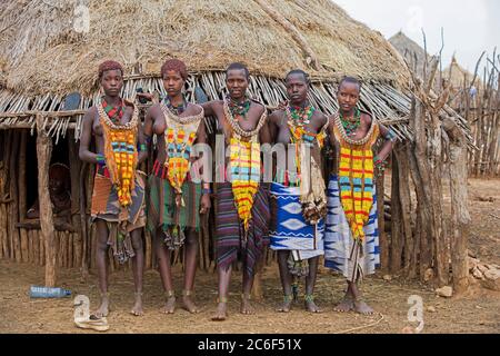 Cinq jeunes femmes noires de la tribu Hamar / Hamer en robe traditionnelle dans le village dans la vallée de la rivière Omo, zone de Debub Omo, sud de l'Éthiopie, Afrique Banque D'Images