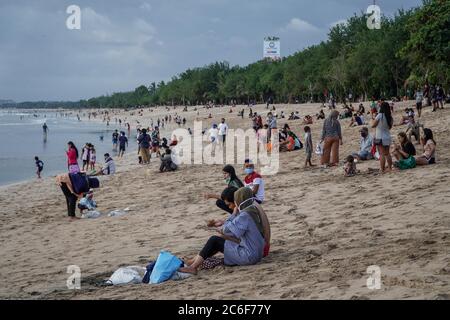 Badung, Bali, Indonésie. 9 juillet 2020. Les troupeaux de personnes à Kuta Beach attendent pour le coucher du soleil. Les autorités locales commencent à rouvrir la célèbre icône touristique de Kuta Beach pour les citoyens de Bali comme une étape du plan ''nouvelle norme'. Kuta Beach est fermée depuis le 30 mars 2020 en raison de préoccupations liées au coronavirus Covid-19. Credit: Dicky Bisinglasi/ZUMA Wire/Alay Live News Banque D'Images