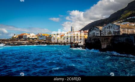 panorama grand angle de la ville du village de pêcheurs populaire garachico avec mer rugueuse en premier plan et maisons colorées peintes, avec castillo Banque D'Images