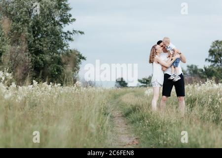 Portrait de la famille heureuse de maman, papa et fils qui marche dehors sur la nature. Jeune famille heureuse. Mère, père et petit fils Banque D'Images