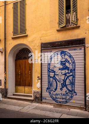 Panneau publicitaire sur un volet métallique sur une maison traditionnelle de couleur jaune à Bologne. Italie Banque D'Images