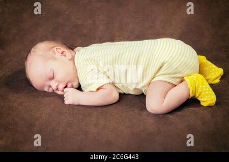 Magnifique bébé garçon de nouveau-né dormant paisiblement sur la couverture marron douce Banque D'Images
