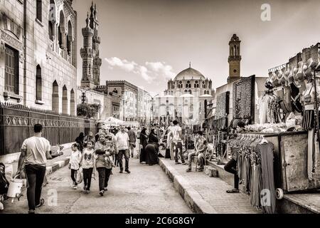 Foule marchant dans la rue Azhar devant l'entrée principale de la mosquée Al Azhar et de la mosquée Abu Al Dahab au Caire Banque D'Images