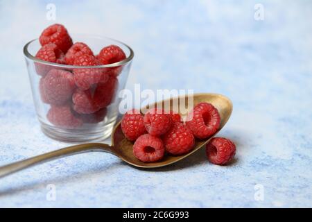 Framboises en cuillère et bol en verre, Allemagne Banque D'Images