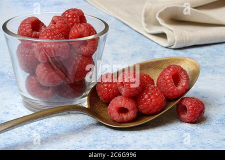 Framboises en cuillère et bol en verre, Allemagne Banque D'Images