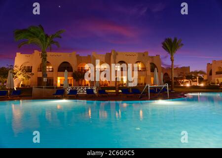 Piscine avec palmiers au coucher du soleil, Hilton Nubian Resort, Al Qusair, Marsa Alam, Egypte Banque D'Images