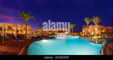 Piscine avec palmiers au coucher du soleil, Hilton Nubian Resort, Al Qusair, Marsa Alam, Egypte Banque D'Images