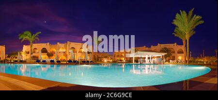 Piscine avec palmiers au coucher du soleil, Hilton Nubian Resort, Al Qusair, Marsa Alam, Egypte Banque D'Images