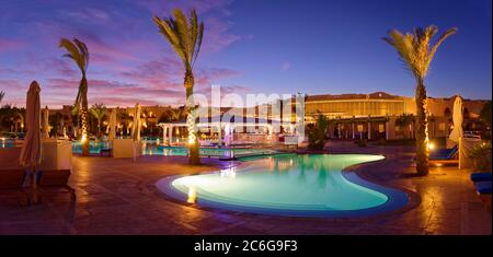 Piscine avec palmiers au coucher du soleil, Hilton Nubian Resort, Al Qusair, Marsa Alam, Egypte Banque D'Images