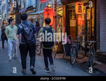 Piéton dans l'allée étroite du quartier de Shimokitazawa, Tokyo, Japon la nuit. Banque D'Images