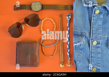 Vue de dessus des accessoires pour homme. Concept Hipster ou homme moderne. Accessoires pour une promenade. Accessoires de mode pour homme, plat sur fond rose corail Banque D'Images