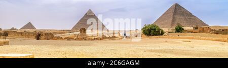 Vue panoramique sur le complexe de la pyramide de Gizeh qui comprend le Temple de la Vallée et le mystérieux Sphinx. Banque D'Images