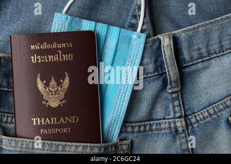 Tourisme et le concept de voyage dans la nouvelle normale après Covid-19 / pandémie de coronavirus.Thai Passeport avec masque médical dans la poche de jeans avec espace de copie. Banque D'Images