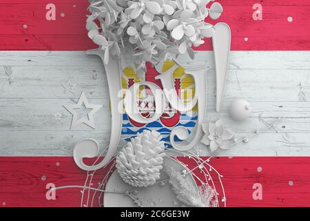 Drapeau de la Polynésie française sur une table en bois avec texte Joy. Noël et nouvel an, célébration national concept avec décor blanc. Banque D'Images