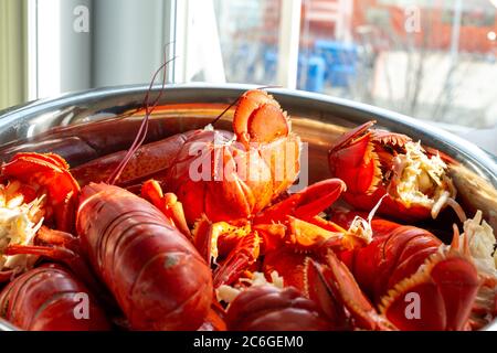 Un grand bol de homard cuit se trouve sur une table dans un restaurant près d'une fenêtre lumineuse. Banque D'Images