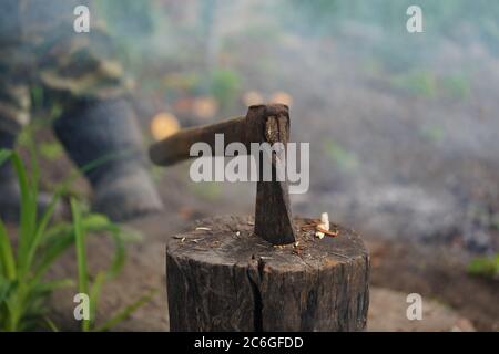 Gros plan de la hache collée dans la souche. Instrument lourd pour hacher le bois. Banque D'Images